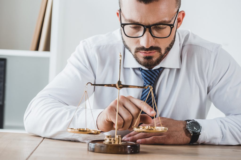 business adviser touching scales with coins in office